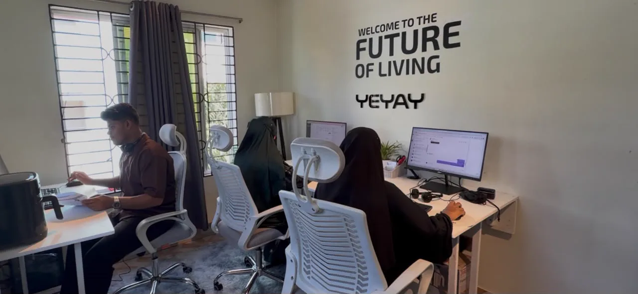 YEYAY team at work under the Welcome to the Future of Living wall
